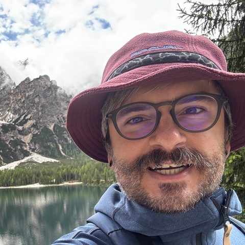 Artsiom Menshakou outdoors above a lake in the Dolomites
